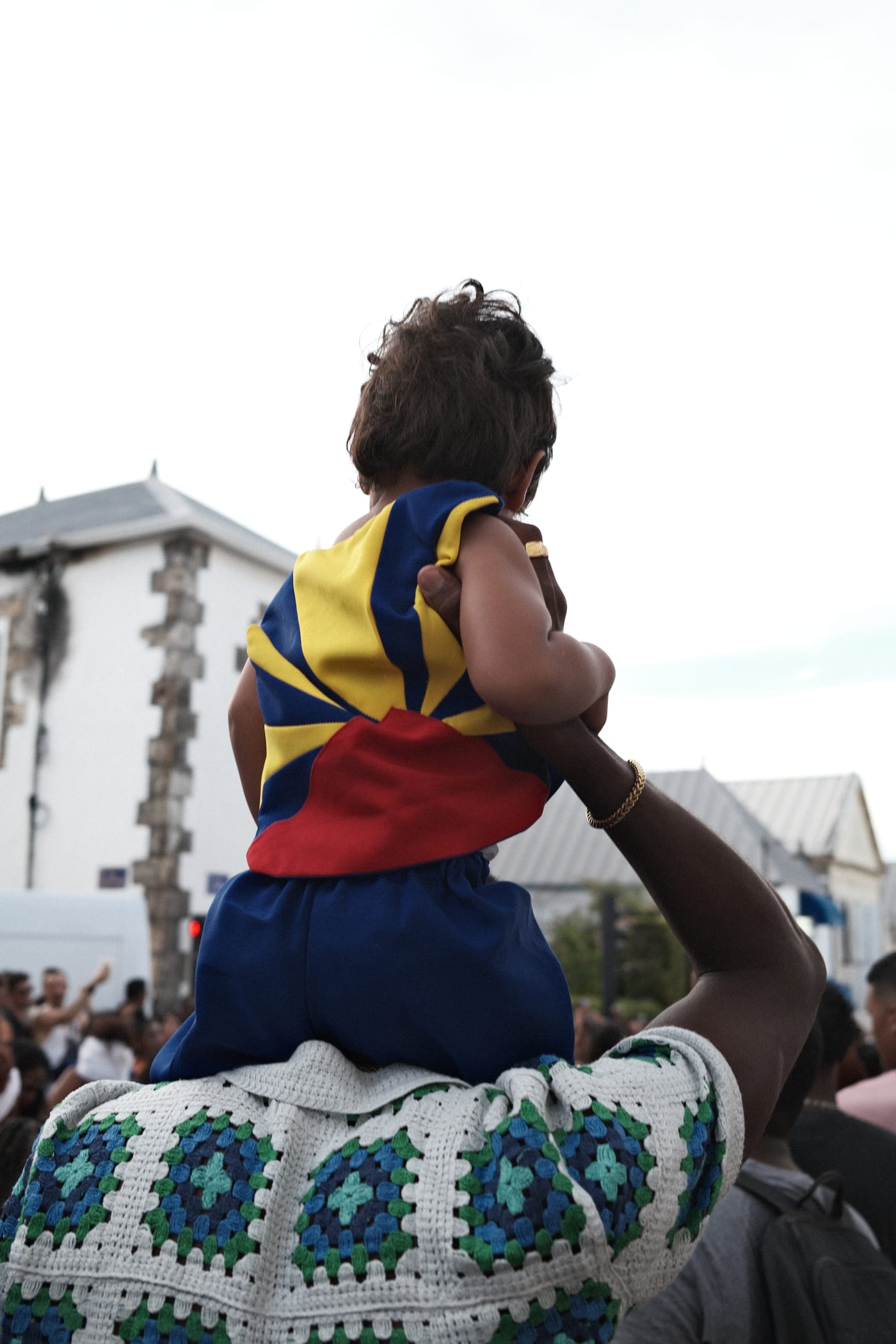Un enfant sur les épaules de son père, dans la foule du défilé du 20 décembre